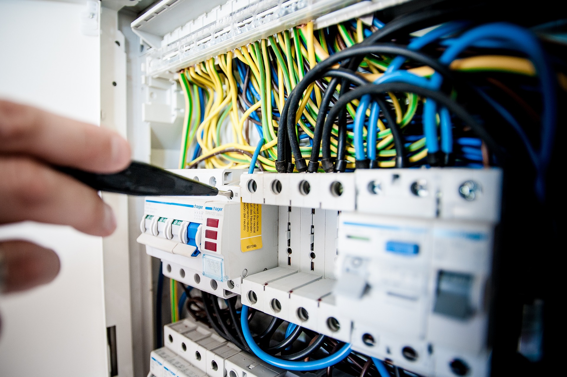 Eine Elektrofachkraft die Arbeiten an eine Sicherungskasten vornimmt